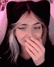 a close up of a woman covering her mouth with her hand .