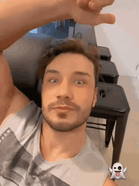 a man with a beard is laying on a couch with a ghost on his tongue