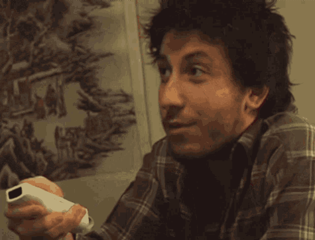 a man is covering his face with his hands in front of a painting