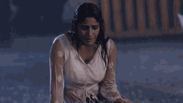 a woman in a white top is sitting in the rain