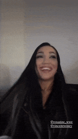 a woman with long black hair is smiling and wearing a leather jacket