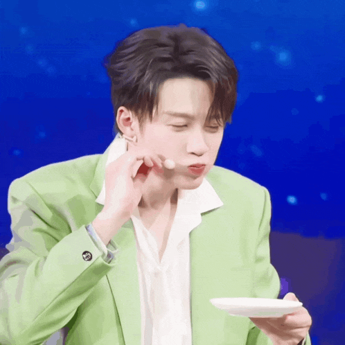 a man in a green jacket is holding a plate in his hand