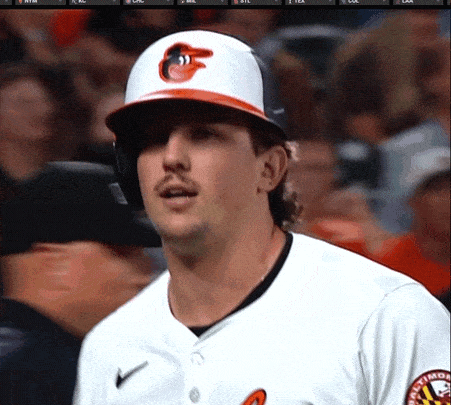 a man wearing a baltimore orioles baseball uniform stands in the dugout