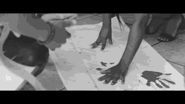 a black and white photo of a child 's hand prints on a piece of paper