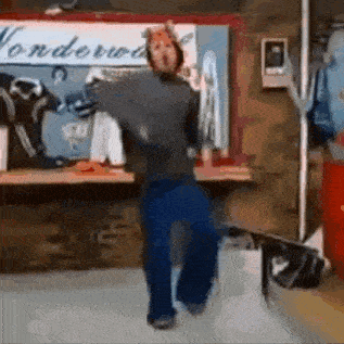 a man in a mask is dancing in front of a sign that says wonderland .