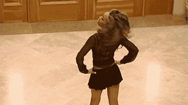 a woman is dancing on a tiled floor in a room .