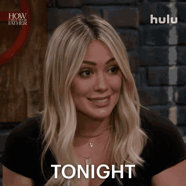 a woman in a black shirt says tonight in front of a brick wall