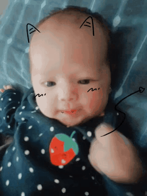 a baby with a drawing of a cat on his head