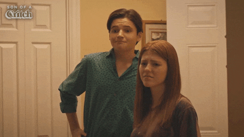 a boy and a girl are standing in front of a door with the words son of a glitch on the bottom