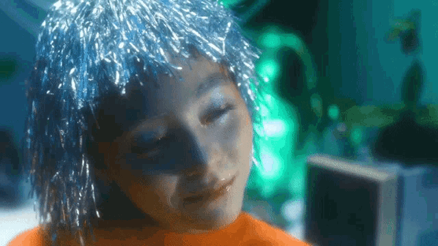 a close up of a person 's face with blue hair