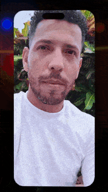 a man with a beard and a white shirt takes a selfie