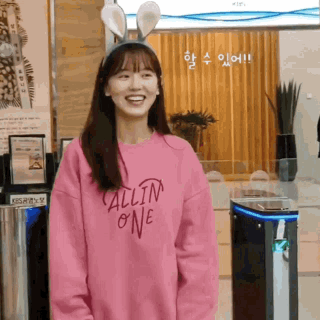 a girl wearing a pink all in one sweatshirt