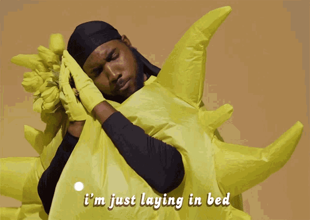 a man is laying in bed wearing a yellow costume