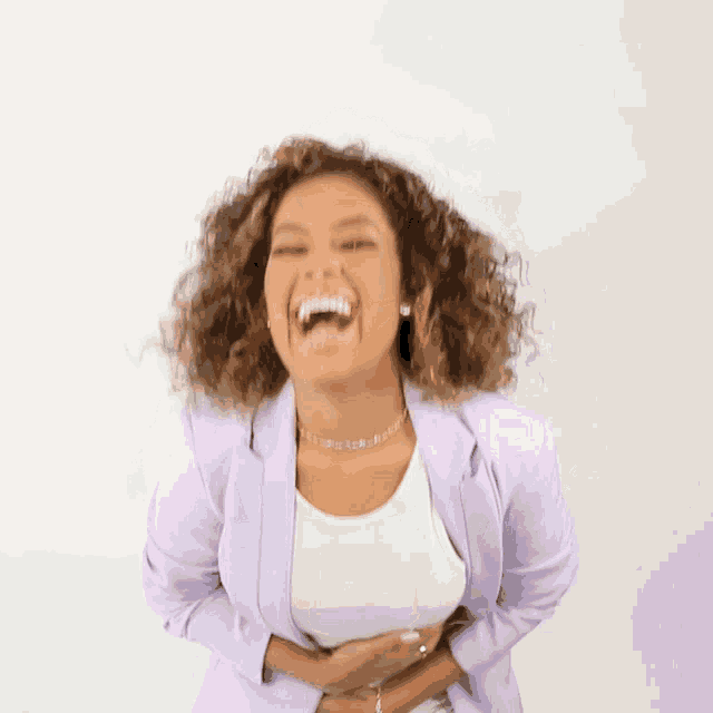 a woman in a purple jacket is laughing