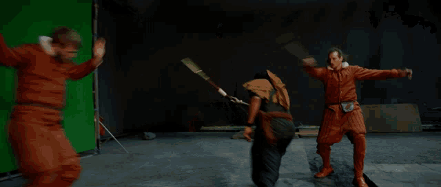 a green screen is behind two men fighting