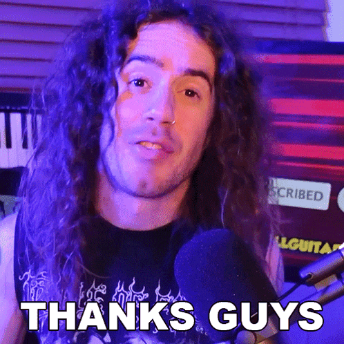 a man with long curly hair is giving a thanks guys sign