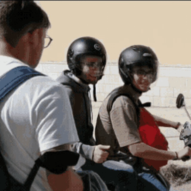 two men wearing helmets are riding motorcycles