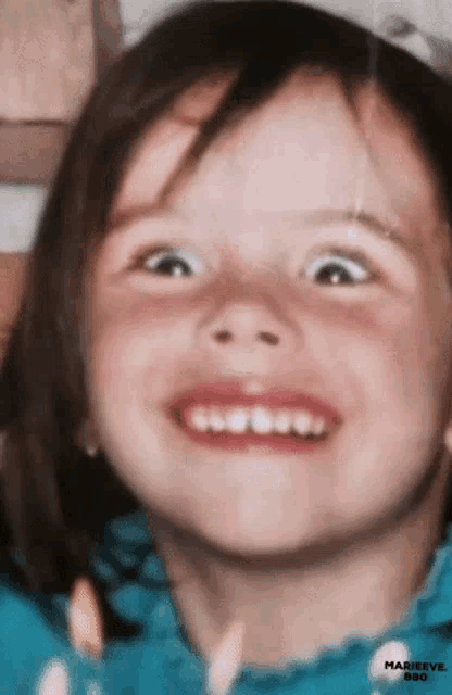 a close up of a little girl 's face with marieeve 880 written below it