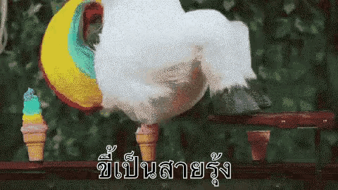 cotton candy is being blown out of an ice cream cone in front of a rainbow