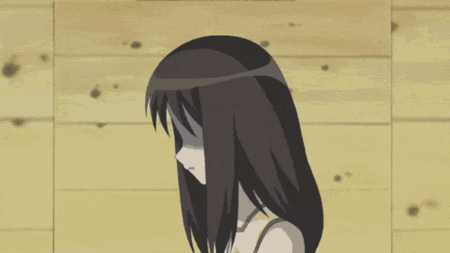 a girl with black hair covering her face with her hand