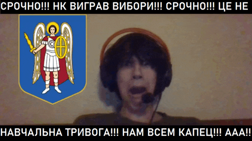 a man wearing headphones and a microphone in front of a coat of arms with an angel holding a sword