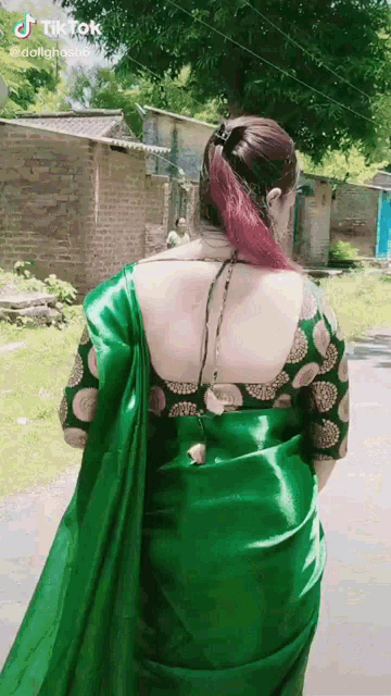 the back of a woman wearing a green saree