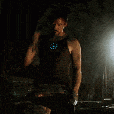 a man in a black tank top with a light on his chest