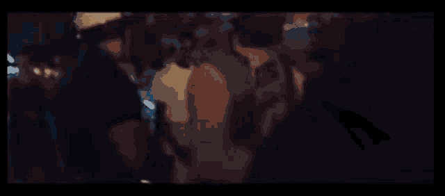 a blurry picture of a group of people standing in a dark room at night .