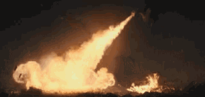 a person is holding a torch that is shooting flames out of it