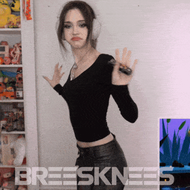 a woman wearing headphones is standing in front of a wall that says breesknees