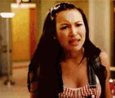 a woman with a very large breast is making a funny face in a hallway .