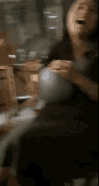 a blurry picture of a person sitting in a chair holding a ball .