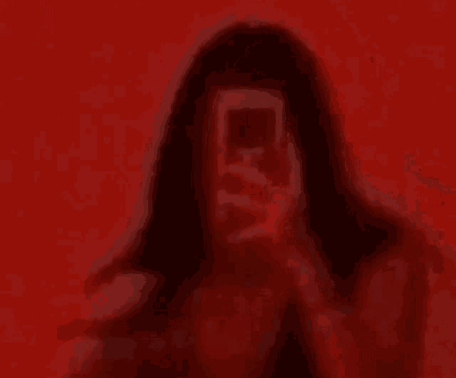 a woman is taking a picture of herself with her phone in front of her face .