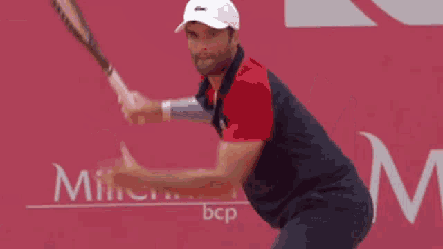 a man is swinging a tennis racket in front of a millennium bcp sign