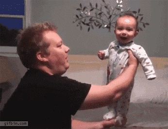 a man is holding a baby in his arms and the website gifbin.com is on the bottom of the screen