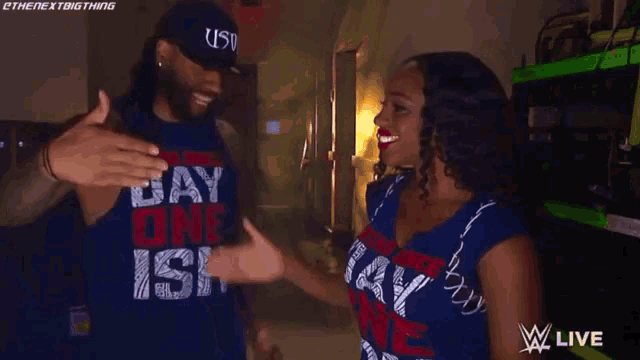 a man and a woman are giving each other a high five and the woman is wearing a shirt that says ish