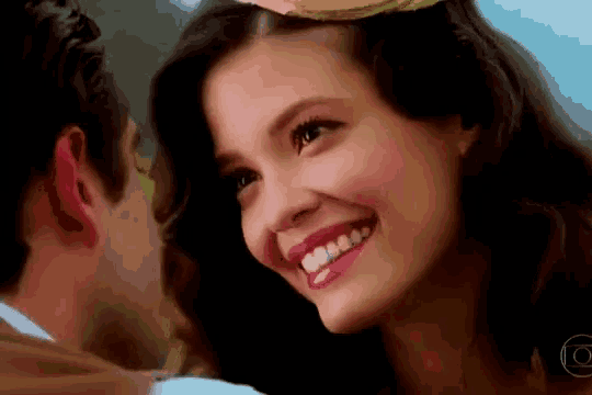 a close up of a woman 's face with a man 's face in the background