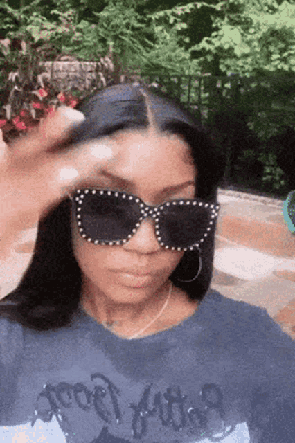 a woman wearing sunglasses and a t-shirt that says ' foo fighters ' on it