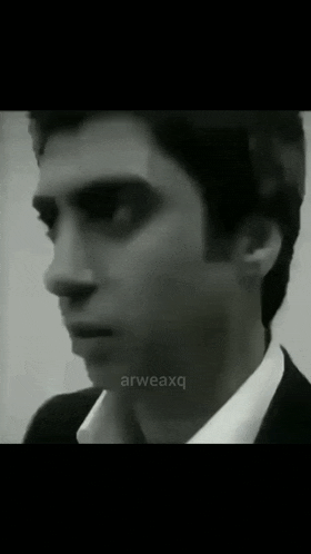 a close up of a man 's face in a black and white photo with the words arweaxq on the bottom