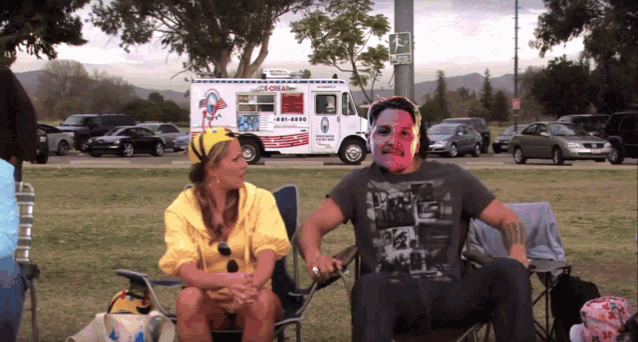 a man and woman sit in front of an ice cream truck that says kona