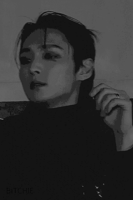 a black and white photo of a young man wearing a black turtleneck .