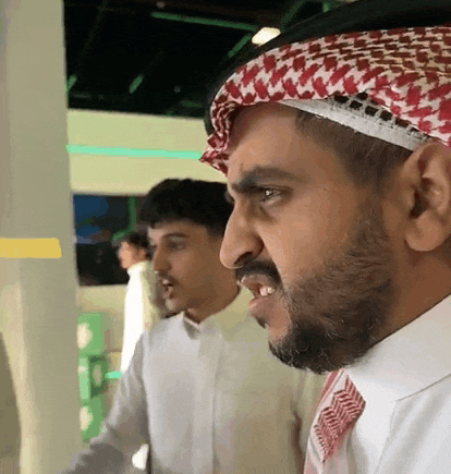 a man with a beard is wearing a head scarf and a white shirt