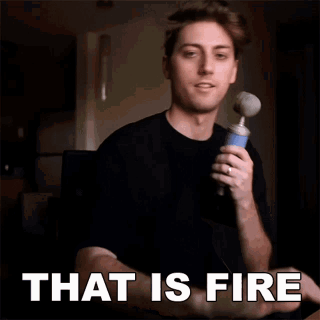 a man is holding a microphone with the words that is fire written below him