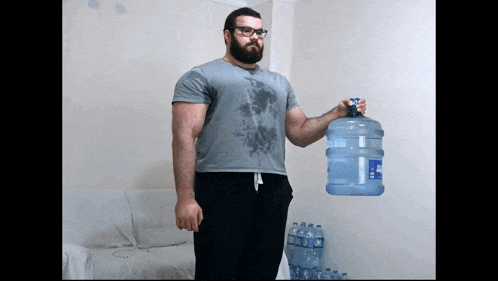 a man is holding a large bottle of water that says aquafina