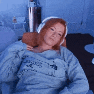 a woman wearing headphones and a sweater that says ' loose ' on it