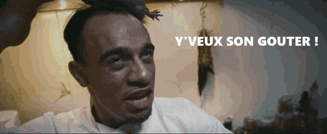 a man with a frog on his head and the words y'veux son gouter below him