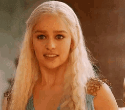 a woman with long blonde hair is wearing a blue top