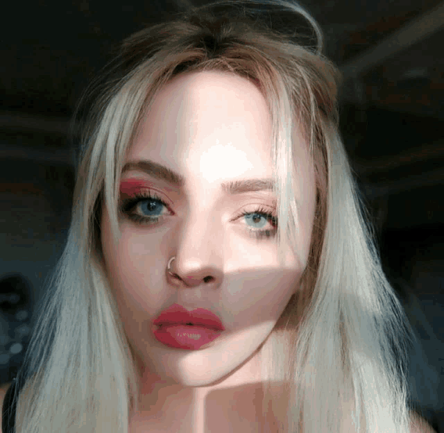 a woman with a nose ring and red lipstick