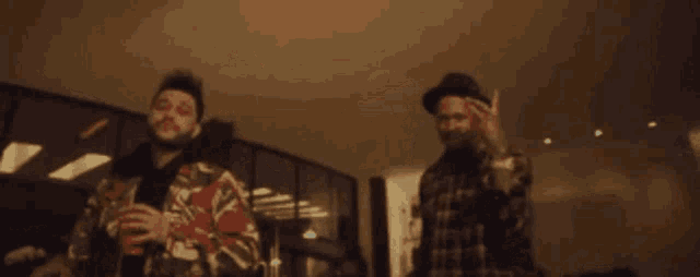 a couple of men are standing next to each other in a room .