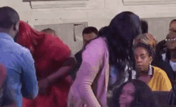 a woman is dancing in a crowd of people at a concert .